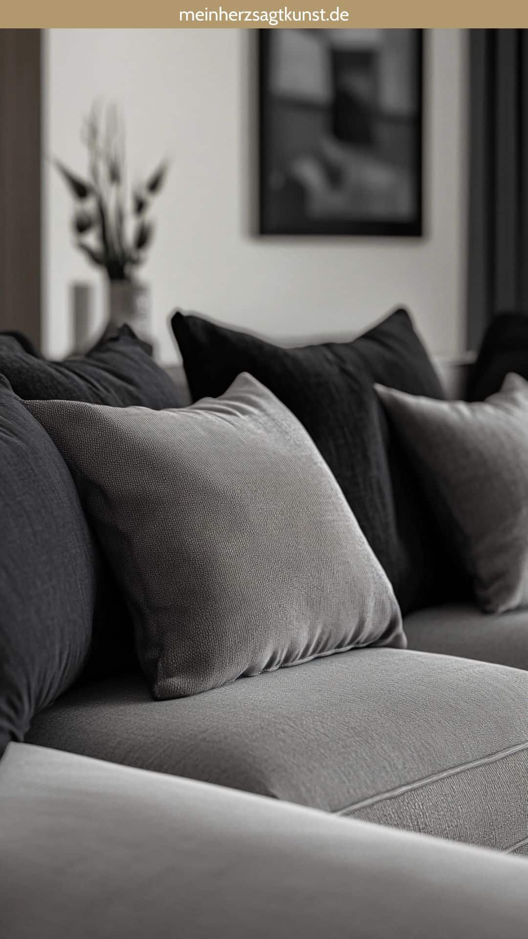 Graues Sofa mit grauen und schwarzen Kissen, minimalistisches Design