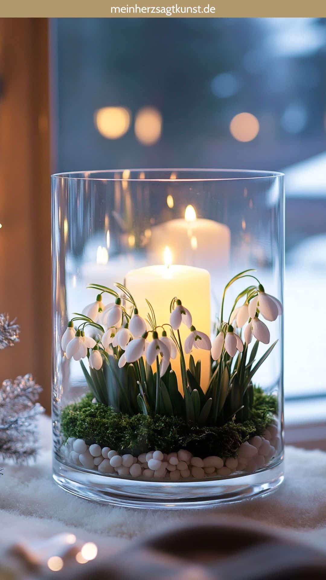 Elegantes Arrangement aus Schneeglöckchen um Kerzen im Glas