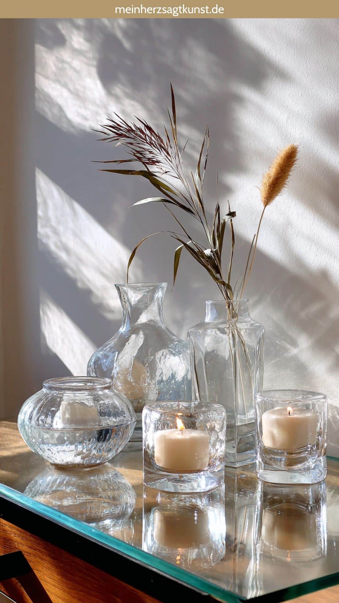 Transparente Glasvasen und Windlichter, die das winterliche Sonnenlicht reflektieren.